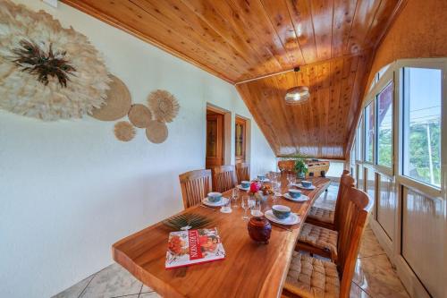 a dining room with a wooden table with chairs at Kaz Latania in Étang-Salé