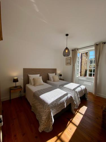 a bedroom with two beds and a window at Domaine de Cazal - Gîte 4 pers au coeur d'un Domaine Privé avec Piscine, Nature & Calme près de Sarlat in Saint-Cyprien