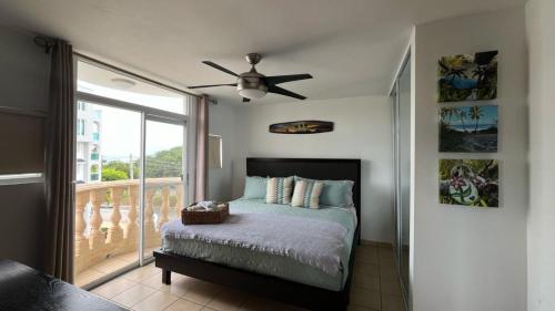 a bedroom with a bed and a ceiling fan at Costa Ensenada Penthouse 505 across the street from Balneario beach in Rincon