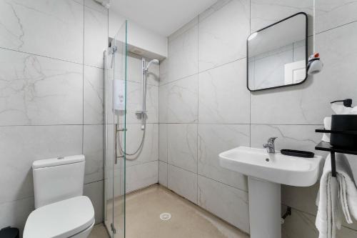 Un baño con ducha, inodoro y lavabo. en Coorie Nook, en Windermere