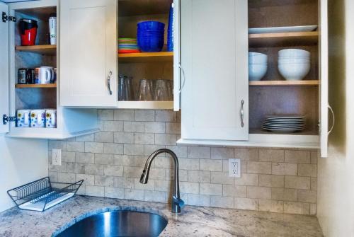 a kitchen with white cabinets and a sink at 3BR Beautiful Remodeled Victorian w/ Beach Locker in Ocean Grove