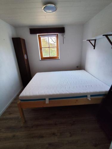a bed in a room with a window at FeWo Pfaffenhofen-Ortsteil Blick ins Grüne in Pfaffenhofen an der Ilm