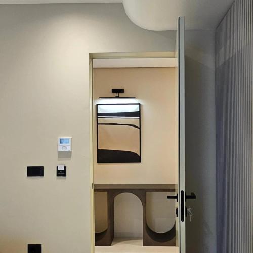 Una puerta a un baño con un espejo en la pared. en Imperial Suites Vlora, en Vlorë