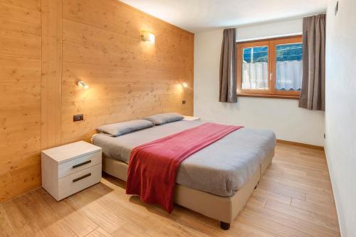 ein Schlafzimmer mit einem Bett und einem Fenster in der Unterkunft Appartamenti Via Dell'Asilo in Isolaccia