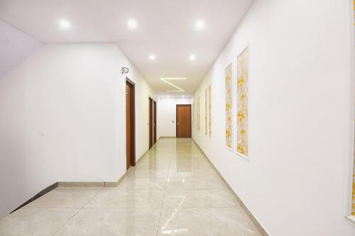 a hallway with white walls and a tile floor at FabHotel AB Residency in Ludhiana