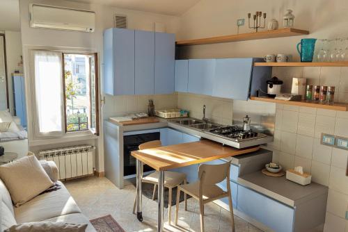 eine Küche mit blauen Schränken und einem Holztisch in der Unterkunft lakefront and parking - Lakefront Escape in Desenzano del Garda