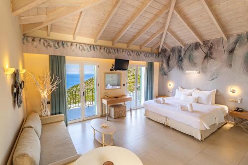 a bedroom with a large bed and a living room at Petani Bay Hotel - Adults Only in Vovikes