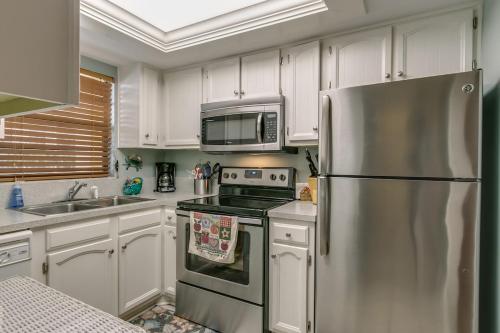 a kitchen with a stainless steel refrigerator and a microwave at Beautiful Ocean view Townhouse in Cocoa Beach