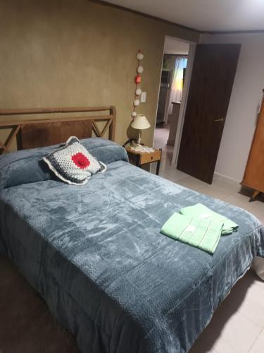a bedroom with a blue bed with two towels on it at Depto 4 in Sierra de la Ventana