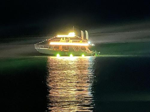 a boat with lights on the water at night at Yate PORTOBELO LUXURY in Buenaventura