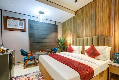 Un dormitorio con una cama grande con almohadas rojas. en J Residency Near Nizamuddin Railway Station, en Nueva Delhi