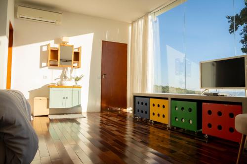 a living room with a flat screen tv on a dresser at Cabana Pico do Gavião in Andradas