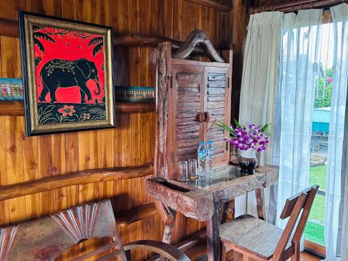 une chambre avec un bureau et une image d'éléphant dans l'établissement Thai Tom s GuestHouse, à Chiang Mai