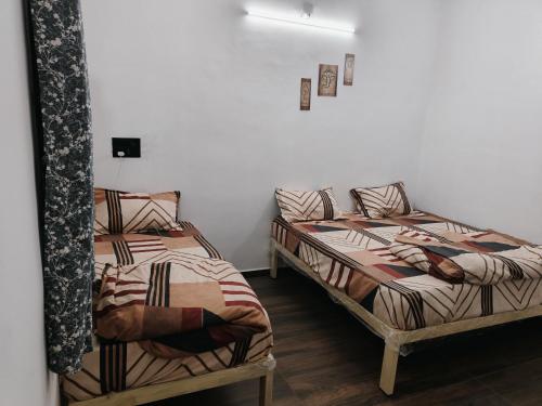 two beds sitting next to each other in a room at Shivay Adventure in Kevadia