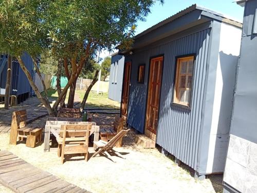 何塞伊格纳西奥Pura vida hostel的一间小房子,配有野餐桌和椅子