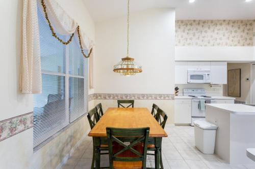 Una cocina con una mesa y sillas de madera. en SERENE & ATTRACTIVE 3BR HEATED POOL/SPA HOME, en Estero