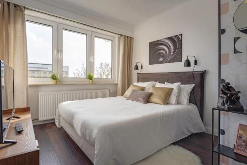 a bedroom with a large white bed and two windows at Studio des roses place des Martyrs hyper centre in Ferme Thibesart
