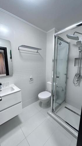 a white bathroom with a shower and a toilet at Casa Joy in Bucharest