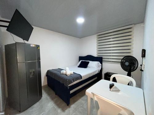 ein Schlafzimmer mit einem Bett, einem Tisch und einem Schreibtisch in der Unterkunft Apartaestudio Vacacional en Girardot, piscinas, Jacuzis, parqueadero para moto in Girardot
