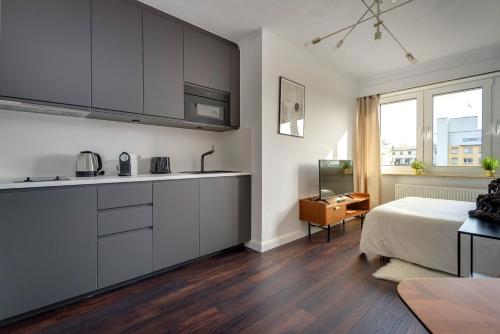 a kitchen with white cabinets and a bed in a room at Studio des roses place des Martyrs hyper centre in Ferme Thibesart