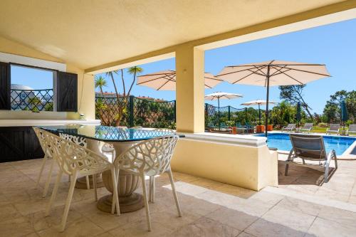 a patio with a table and chairs and a pool at MBird 19 Estoril Apartments 203 in Estoril