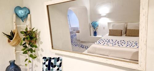 a mirror on a wall with a bed in a room at Loveroom La Cesarine Jacuzzi privé in Mougins
