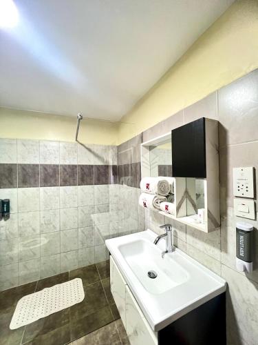 a white bathroom with a sink and a mirror at Hadassah Hotel in Nairobi