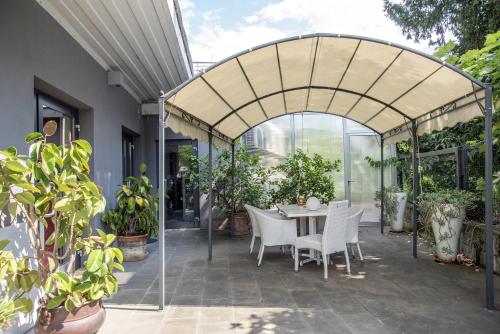 invernadero con mesa, sillas y plantas en Room GIOVY, en San Martino Buon Albergo