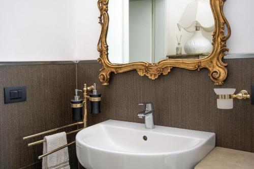 Un baño con un lavabo blanco y un espejo. en Room GIOVY, en San Martino Buon Albergo