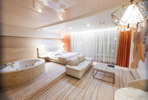 een slaapkamer met een bed en een bad in een kamer bij Hotel Palladium in Odessa