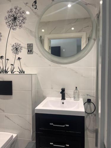 a bathroom with a sink and a mirror at Paradise in Marston Green