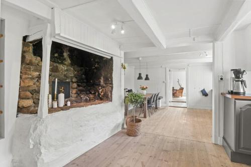 a living room with a stone wall with a fireplace at 200-Year-Old House By The Southern Archipelago in Mandal