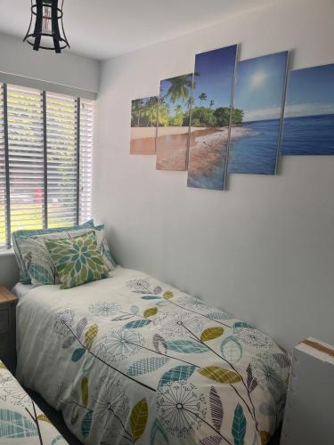 a bedroom with a bed and some paintings on the wall at Paradise in Marston Green