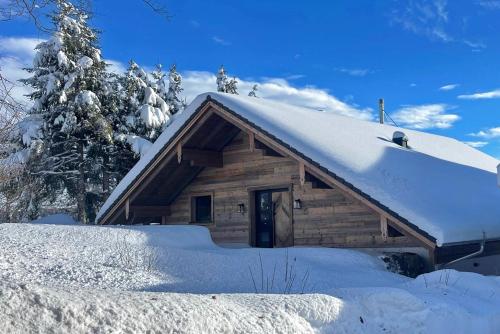 a log cabin with snow on the roof at Chalet Mädesüss in Weitnau