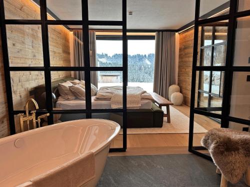 a bathroom with a tub and a bed in a room at Chalet Mädesüss in Weitnau
