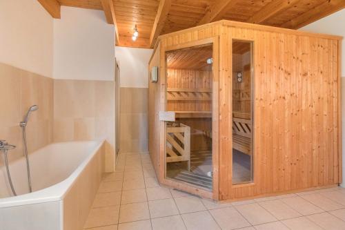 a bathroom with a tub and a wooden cabinet at Skiblickhaus in Russbach am Pass Gschütt