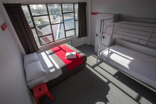 a bedroom with two bunk beds and a window at Urbanz in Christchurch