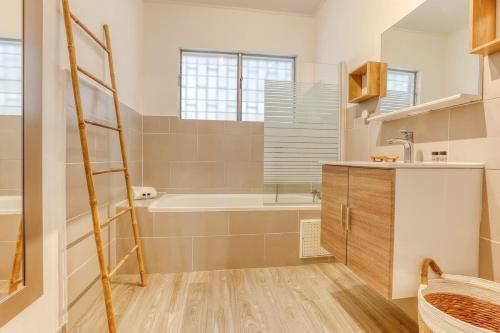 een badkamer met een ladder, een bad en een wastafel bij Kaz Nautilia in La Saline Les hauts 