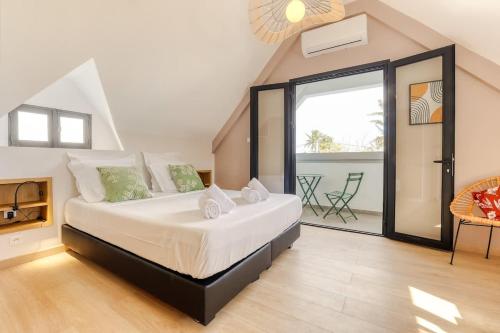 een slaapkamer met een groot bed en een balkon bij Kaz Nautilia in La Saline Les hauts 
