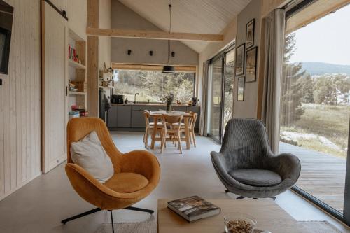 a living room with two chairs and a table at Wood Rest, MyWeek in Stronie Śląskie