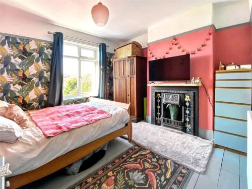 a bedroom with a bed and a fireplace at Drew Street Digs in Brixham
