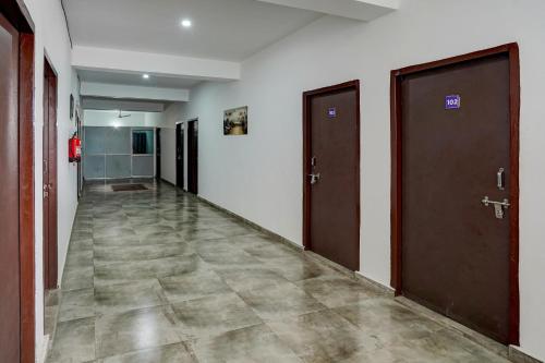 un couloir vide avec deux portes et du carrelage dans l'établissement Super Hotel O Omi Rooms, à Gurgaon