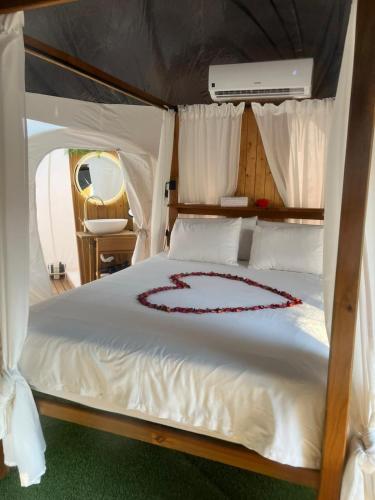 a bed in a tent with a heart on it at Glamping Burbuja Los Almendros in Málaga