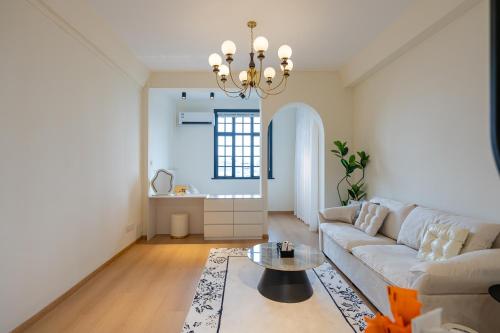 Shanghai Zighouse--The Bund Premium Apartment Suites في شانغهاي: غرفة معيشة مع أريكة وطاولة