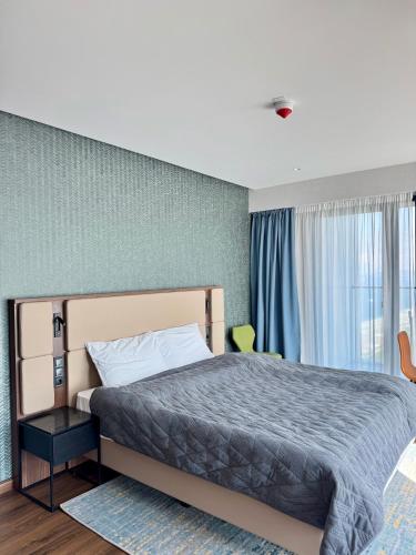 a bedroom with a bed and a large window at Apartment with sea View in Batumi