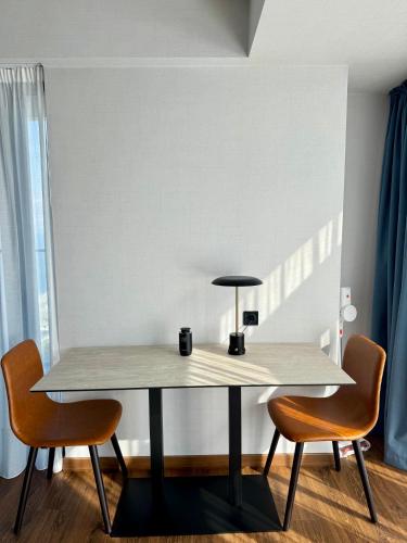 a table with two chairs and a lamp on it at Apartment with sea View in Batumi