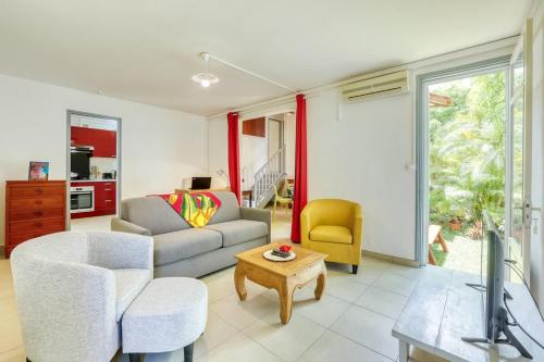 a living room with a couch and a table at Kaz Santa Maria in Saint-Leu