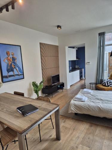 a living room with a bed and a table at Cozy apartment in Utrecht in Utrecht