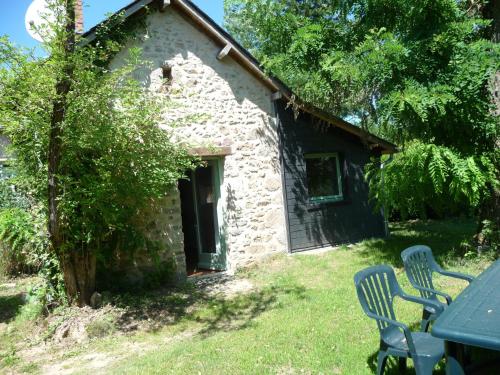 Maison en pierre avec 2 chaises et une table dans l'établissement La Maison du Sabotier, à Corancy