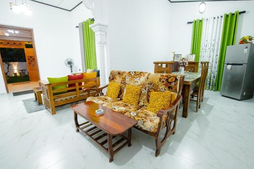 ein Wohnzimmer mit Sofa und Tisch in der Unterkunft Chali' Villa in Matale